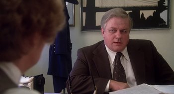 Movie still from “When a Stranger Calls” (1979), directed by Fred Walton – A man in a suit and tie sitting at a table; Close Up shot, Over the shoulder angle