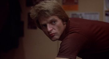 Movie still from “When a Stranger Calls” (1979), directed by Fred Walton – A person wearing a brown t - shirt; Close Up shot, Low angle