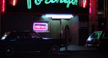 Movie still from “When a Stranger Calls” (1979), directed by Fred Walton – A woman standing in front of a car at night; Wide shot, Low angle