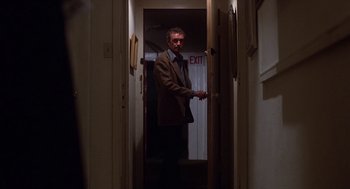 Movie still from “When a Stranger Calls” (1979), directed by Fred Walton – A man standing in a doorway in a room; Medium shot, Over the shoulder angle