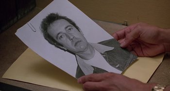 Movie still from “When a Stranger Calls” (1979), directed by Fred Walton – A person holding a picture of a man; Close Up shot, Low angle