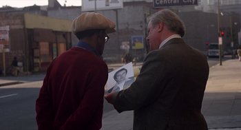 Movie still from “When a Stranger Calls” (1979), directed by Fred Walton – Two men looking at an old photo of a man; Close Up shot, Over the shoulder angle
