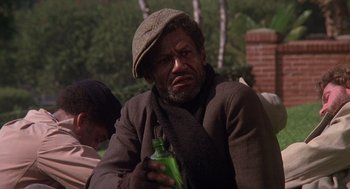 Movie still from “When a Stranger Calls” (1979), directed by Fred Walton – A man with a hat on holding a bottle of beer; Close Up shot, Low angle