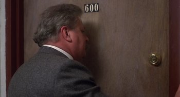 Movie still from “When a Stranger Calls” (1979), directed by Fred Walton – A person wearing a suit near a wall; Close Up shot, High angle