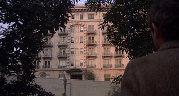 Movie still from “When a Stranger Calls” (1979), directed by Fred Walton – A building with many balconies in the background; Extreme Wide shot, Low angle