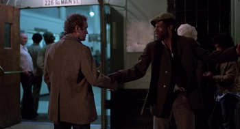 Movie still from “When a Stranger Calls” (1979), directed by Fred Walton – Two men are shaking hands on the street; Medium shot, Over the shoulder angle