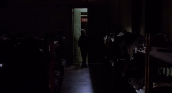 Movie still from “When a Stranger Calls” (1979), directed by Fred Walton – A person standing in a dark room in front of a door; Wide shot, High angle