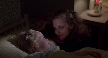 Movie still from “When a Stranger Calls” (1979), directed by Fred Walton – A woman and a child laying in bed; Close Up shot, High angle