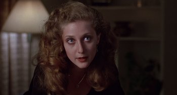 Movie still from “When a Stranger Calls” (1979), directed by Fred Walton – A person with long curly hair; Close Up shot, Over the shoulder angle