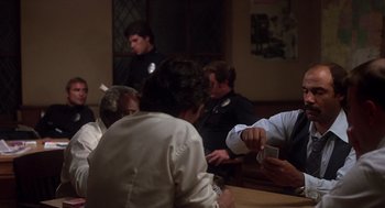 Movie still from “When a Stranger Calls” (1979), directed by Fred Walton – A group of people sitting around a table; Medium shot, Over the shoulder angle