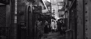 Movie still from “When a Woman Ascends the Stairs” (1960), directed by Mikio Naruse – A group of people walking down a street; Wide shot, High angle