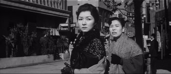 Movie still from “When a Woman Ascends the Stairs” (1960), directed by Mikio Naruse – Two women are walking down the street together; Medium shot, Low angle