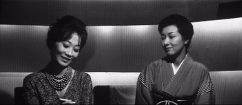 Movie still from “When a Woman Ascends the Stairs” (1960), directed by Mikio Naruse – A couple of women standing next to each other; Medium shot, High angle