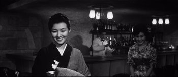 Movie still from “When a Woman Ascends the Stairs” (1960), directed by Mikio Naruse – An asian woman in a black and white photo; Medium shot, Low angle