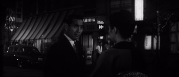 Movie still from “When a Woman Ascends the Stairs” (1960), directed by Mikio Naruse – A black and white photo of a man and a woman talking; Medium shot, Over the shoulder angle
