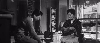Movie still from “When a Woman Ascends the Stairs” (1960), directed by Mikio Naruse – A man and a woman sitting in a room; Medium shot, Low angle