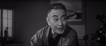 Movie still from “When a Woman Ascends the Stairs” (1960), directed by Mikio Naruse – An older man wearing a robe is sitting in a room; Close Up shot, Low angle