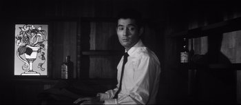 Movie still from “When a Woman Ascends the Stairs” (1960), directed by Mikio Naruse – A black and white photo of a man wearing a shirt and tie; Close Up shot, High angle