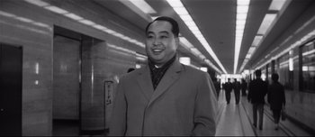 Movie still from “When a Woman Ascends the Stairs” (1960), directed by Mikio Naruse – Black and white photograph of a man smiling for the camera; Medium shot, Low angle