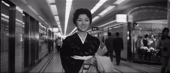 Movie still from “When a Woman Ascends the Stairs” (1960), directed by Mikio Naruse – A woman in a kimono is walking down a hallway; Medium shot, Low angle
