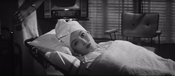 Movie still from “When a Woman Ascends the Stairs” (1960), directed by Mikio Naruse – A woman is laying in a bed with a towel on her head; Close Up shot, High angle