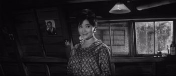 Movie still from “When a Woman Ascends the Stairs” (1960), directed by Mikio Naruse – A woman standing in front of a wall; Close Up shot, Low angle