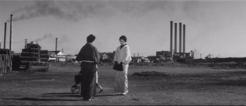 Movie still from “When a Woman Ascends the Stairs” (1960), directed by Mikio Naruse – Two women standing in an open field talking to each other; Extreme Wide shot, Low angle