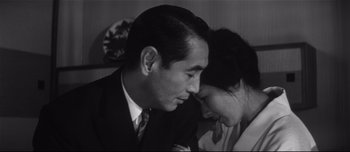 Movie still from “When a Woman Ascends the Stairs” (1960), directed by Mikio Naruse – A man and a woman sitting next to each other in a room; Close Up shot, High angle