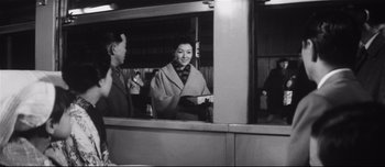 Movie still from “When a Woman Ascends the Stairs” (1960), directed by Mikio Naruse – A man and a woman are standing in a building; Medium shot, Over the shoulder angle