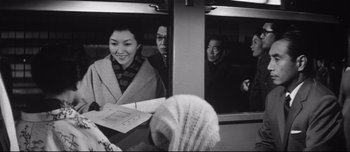 Movie still from “When a Woman Ascends the Stairs” (1960), directed by Mikio Naruse – A group of people sitting at a table in front of a window; Medium shot, Over the shoulder angle
