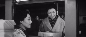 Movie still from “When a Woman Ascends the Stairs” (1960), directed by Mikio Naruse – Two women are standing next to each other on a bus; Medium shot, Low angle