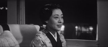 Movie still from “When a Woman Ascends the Stairs” (1960), directed by Mikio Naruse – An old photo of a woman in a kimono smiling; Close Up shot, Low angle