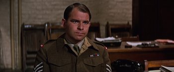 Movie still from “Where Eagles Dare” (1968), directed by Brian G. Hutton – A man in a military uniform is looking at the camera; Close Up shot, Low angle