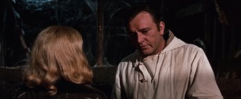 Movie still from “Where Eagles Dare” (1968), directed by Brian G. Hutton – A man and a blonde woman in a dark room; Close Up shot, Over the shoulder angle