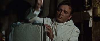 Movie still from “Where Eagles Dare” (1968), directed by Brian G. Hutton – A man in a white jacket is holding a stick; Close Up shot, Low angle