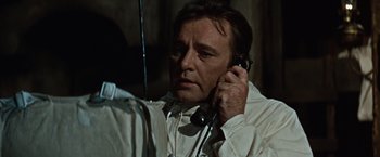 Movie still from “Where Eagles Dare” (1968), directed by Brian G. Hutton – A man holding a phone up to his ear; Close Up shot, Low angle