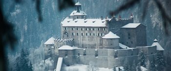 A large castle with snow on it's roof