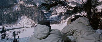 Movie still from “Where Eagles Dare” (1968), directed by Brian G. Hutton – A person wearing a jacket and hat looking out over a snowy mountain range; Wide shot, High angle
