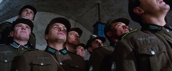 Movie still from “Where Eagles Dare” (1968), directed by Brian G. Hutton – A group of men in uniforms looking up at the sky; Medium shot, Low angle