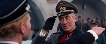 Movie still from “Where Eagles Dare” (1968), directed by Brian G. Hutton – An older man in a uniform saluting with his hand up; Close Up shot, Low angle