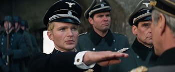 Movie still from “Where Eagles Dare” (1968), directed by Brian G. Hutton – Two men in uniforms are standing next to each other; Close Up shot, Low angle