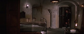 Movie still from “Where Eagles Dare” (1968), directed by Brian G. Hutton – An empty room with a bed , chair , table , and a pillar; Wide shot, High angle