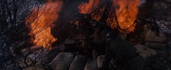 Movie still from “Where Eagles Dare” (1968), directed by Brian G. Hutton – A group of men standing next to each other in front of a fire; Medium shot, High angle