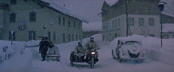 Movie still from “Where Eagles Dare” (1968), directed by Brian G. Hutton – Two men on a motorcycle and a sidecar on a snowy street; Wide shot, High angle