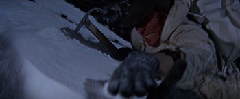Movie still from “Where Eagles Dare” (1968), directed by Brian G. Hutton – A man in a hat is laying in the snow; Close Up shot, Low angle