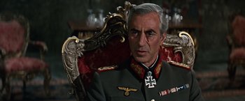Movie still from “Where Eagles Dare” (1968), directed by Brian G. Hutton – An older man wearing a military uniform sitting in a chair; Close Up shot, Low angle