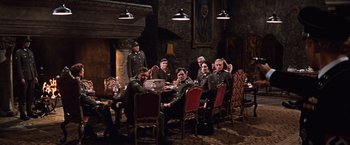 Movie still from “Where Eagles Dare” (1968), directed by Brian G. Hutton – A group of people sitting around a table; Wide shot, High angle