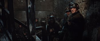 Movie still from “Where Eagles Dare” (1968), directed by Brian G. Hutton – A group of men wearing helmets and holding guns; Medium shot, High angle