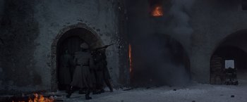 Movie still from “Where Eagles Dare” (1968), directed by Brian G. Hutton – A group of men standing next to each other near a fire; Wide shot, Low angle