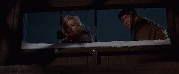 Movie still from “Where Eagles Dare” (1968), directed by Brian G. Hutton – A woman looking out of a window at night; Medium shot, Low angle